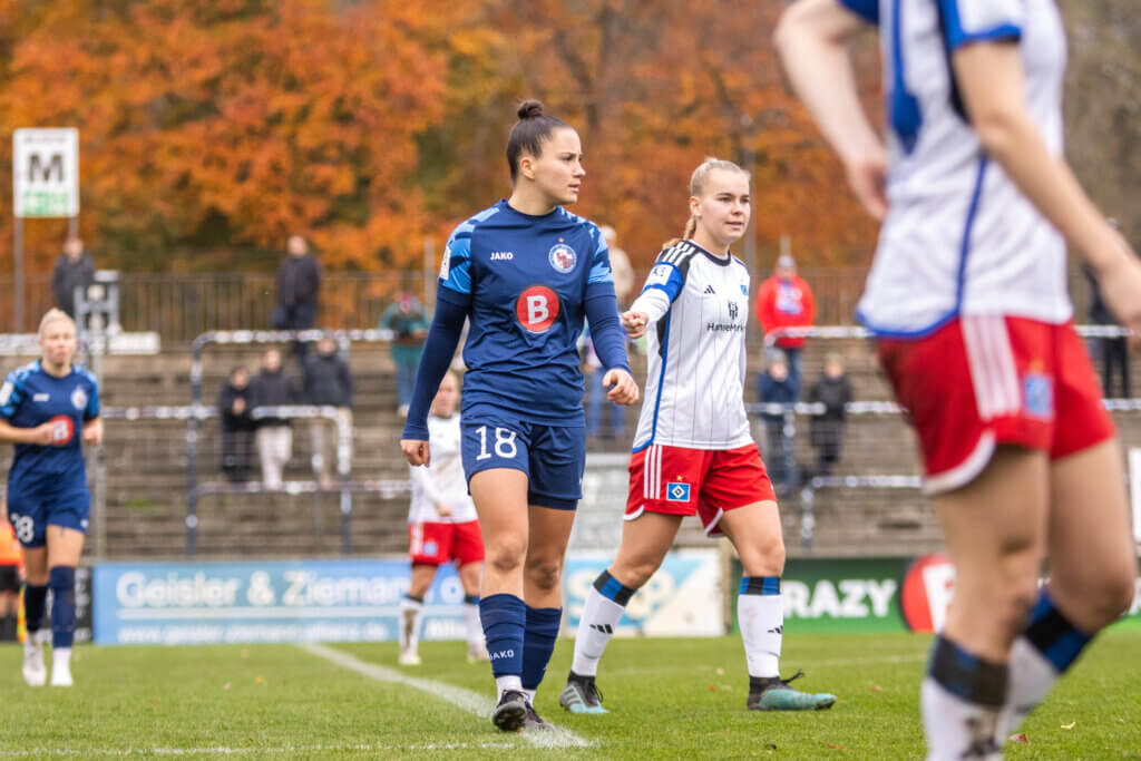 Zu sehen sind Ena Taslidza (im Vordergrund) und Laura Lindner (im Hintergrund), als auch Spielerinnen des HSV, welche sich alle für eine Standardsituation positionieren. 